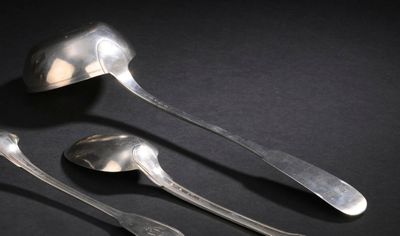trois cuillères et deux petites cuillères posées sur une surface noire