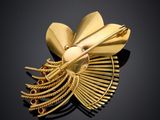 an image of a gold brooch with a flower on top of it