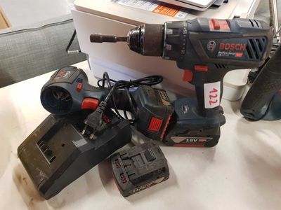 a cordless drill and two batteries on a table
