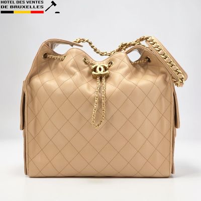 Sac seau Chanel en cuir matelassé beige avec anses en chaîne dorée