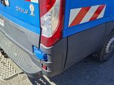 the back end of a blue van parked in a parking lot
