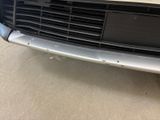 the front end of a white car with a black grille