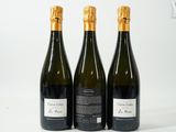 trois bouteilles de vin posées les unes à côté des autres sur une surface blanche