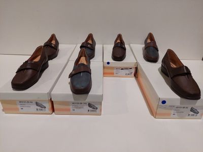 Quatre paires de chaussures marron sont exposées dans une vitrine.