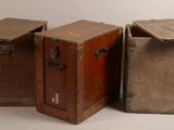 trois vieilles valises sont posées les unes à côté des autres sur une surface blanche