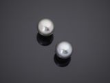 a pair of white pearls on a black surface