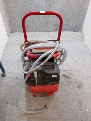 une photo d'un compresseur d'air portable posé au sol