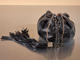 a black purse with a chain around it sitting on a table