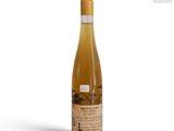 the bottle of wine is sitting on a white surface