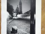 black and white photograph of a street with a clock tower in the background