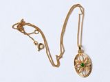 un collier en or avec un pendentif en pierre verte et une chaîne en or