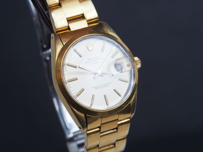 une image montrant un gros plan d'une montre en or sur fond noir