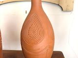 deux vases posés sur une table en bois devant un miroir