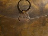 a large metal bowl with a handle on a table