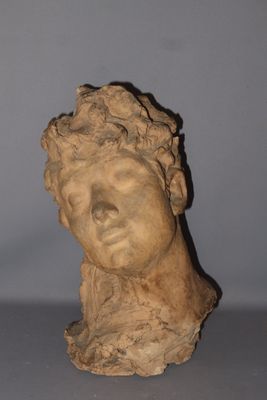 statue of a woman ' s head on a table with a gray background