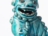 une statue bleue représentant un chien assis sur une table