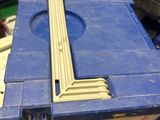 a blue tool box with a piece of wood in it