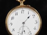 gros plan d'une montre de poche en or sur fond noir