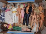une boîte remplie de Barbies et d'autres poupées qui s'y trouvent