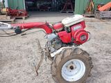 a red tractor that is parked in front of a building