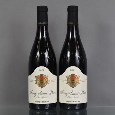 two bottles of wine sitting on top of a table next to each other