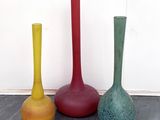 trois vases de couleurs différentes posés par terre