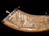 a large horn with carvings on it on a black background
