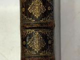 un vieux livre posé sur une table, à côté d'un panneau