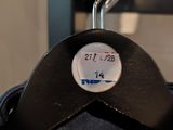 a close up of a black coat hanger with a label on it
