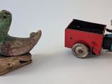 toy figurines of a man on a motorcycle and a duck on a cart
