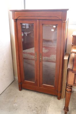 a wooden cabinet with glass doors in a room