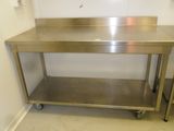 une table en acier inoxydable avec deux tabourets dans un coin