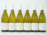 six bouteilles de vin blanc alignées sur une table