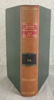 an old book sitting on top of a table next to a white wall