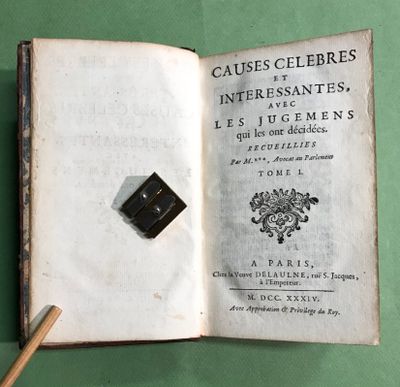 un livre ouvert, sur lequel repose un crayon, posé sur une surface verte