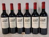 six bottles of red wine lined up in a row