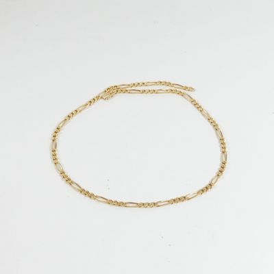un bracelet en chaîne d'or à maillon unique sur fond blanc