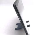 a tablet computer sitting on a stand on a white surface