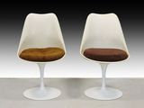 deux chaises « Tulip » blanches avec une assise marron et un piètement blanc