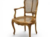 une chaise en bois avec un dossier et des accoudoirs en rotin