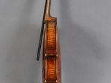 an old violin sitting on top of a table next to a gray wall