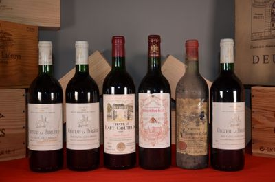 several bottles of wine are lined up on a red table