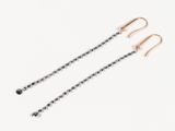 une paire de boucles d'oreilles en diamant noir et blanc sur fond blanc