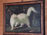 a painting of a white cat hanging on a wall