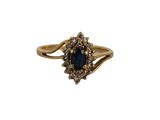 gros plan d'une bague en or avec une pierre bleue