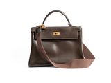 a brown handbag sitting on top of a white surface