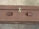 a brown suitcase with numbers on it hanging on a wall