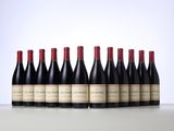 six bottles of red wine lined up in a row on a table