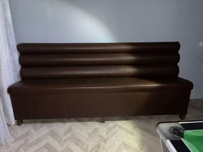 un canapé en cuir marron dans un salon, près d'une fenêtre