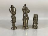 three silver figurines of a man and a woman and a dog